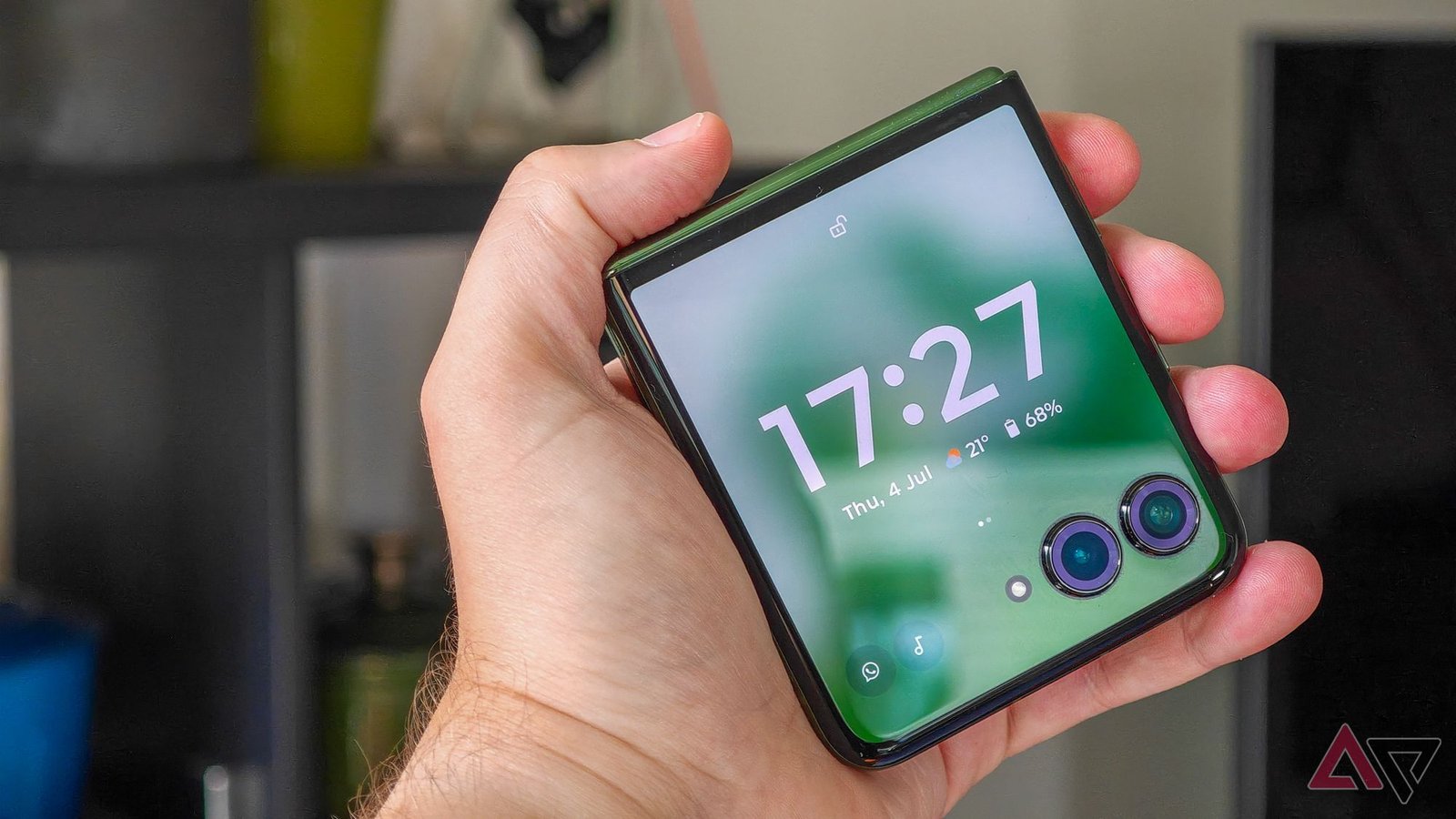 Motorola Razr+ 2024 closed in someone's hand with the lock screen facing the camera